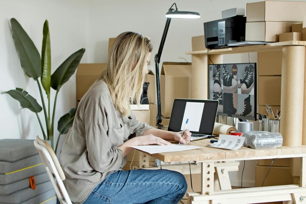 A young woman managing her online store startup, working diligently from her home office in Portugal.